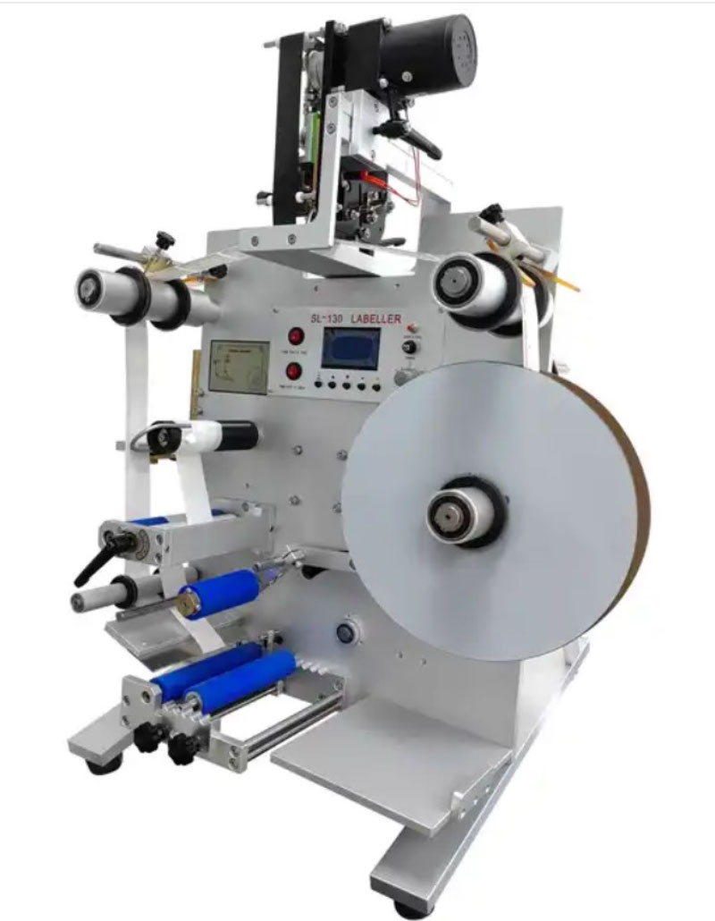 PMA-130_2 Ετικετέζα Κάθετη για στρόγγυλα μπουκάλια και βάζα. Μπροστινή όψη του μηχανημάτος με τα καρούλια της αυτοκόλλητης